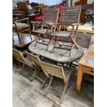 A weathered teak folding oval garden table, length 150cm, depth 91cm, height 74cm together with