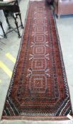 A Belouch red ground runner, approx. 400 x 84cm *Please note the sale commences at 9am.