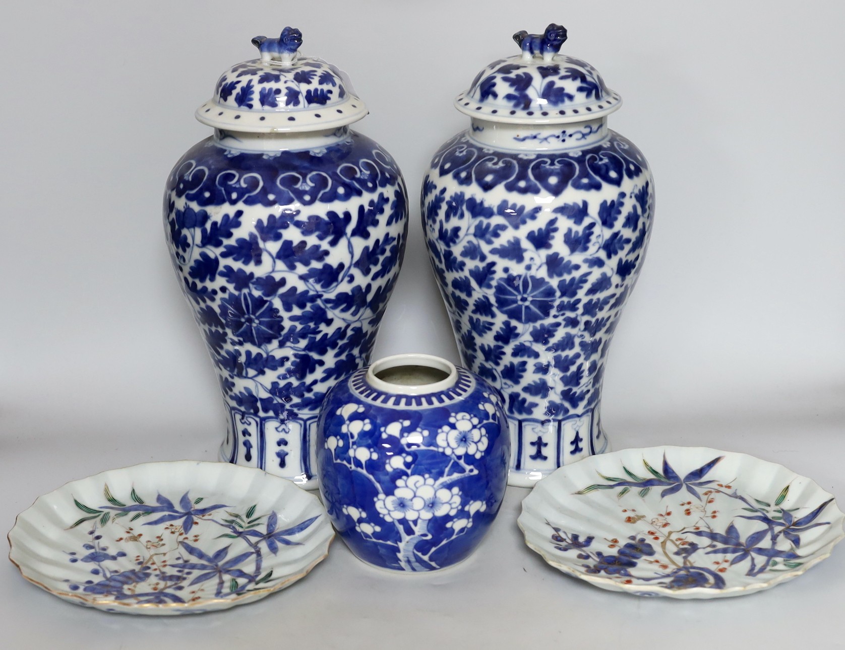 Two early 20th century Chinese blue and white vases with lion dog covers, together with a blue and