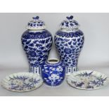 Two early 20th century Chinese blue and white vases with lion dog covers, together with a blue and