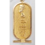 An Egyptian yellow metal pendant, overall 57mm, on a 750 chain, 57cm, gross weight 12.4 grams.