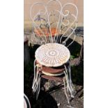 A circular wrought iron garden table and four chairs, diameter 50cm, height 80cm *Please note the