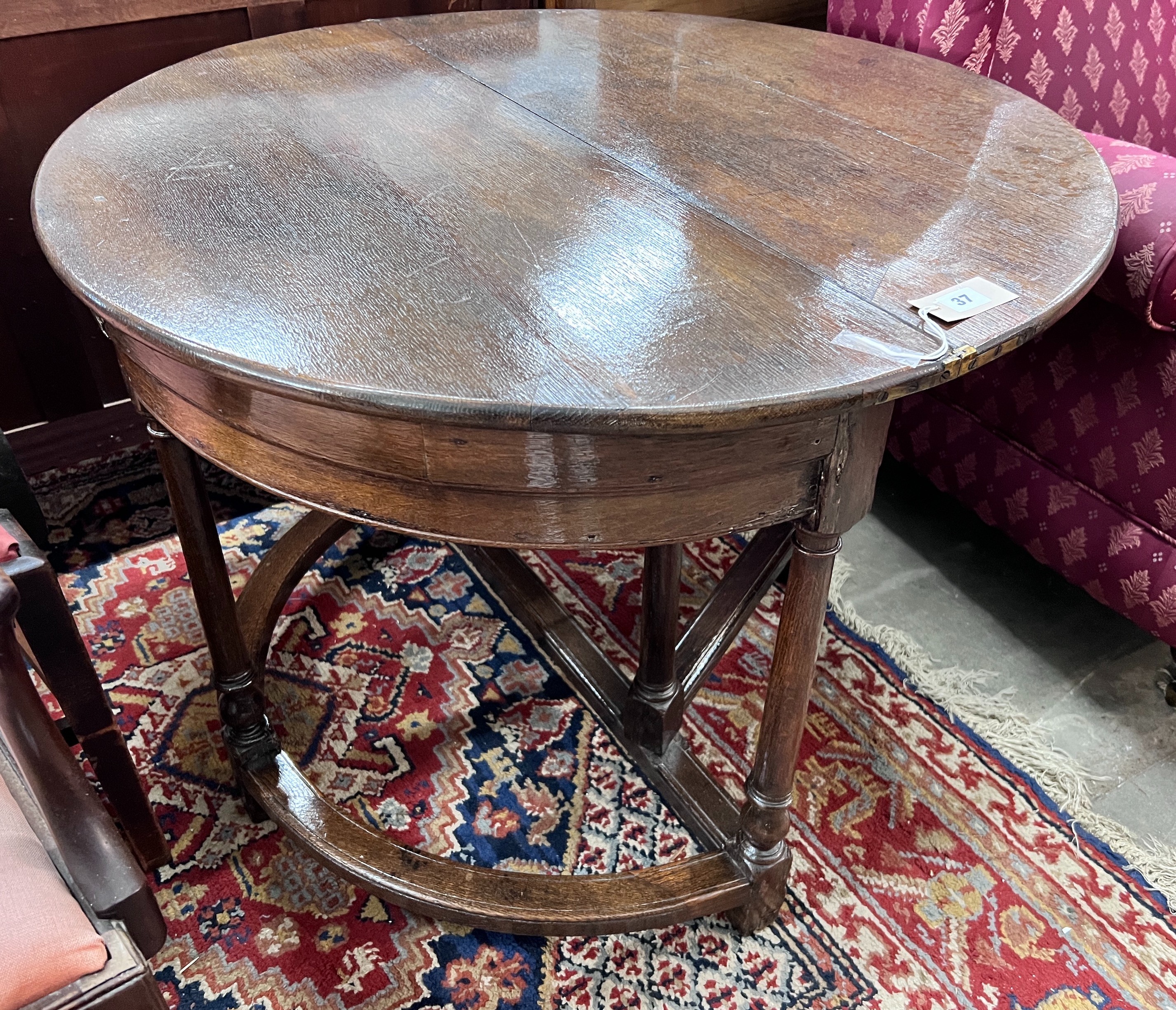 A late 17th century oak D shape folding tea table, diameter 94cm, height 70cm *Please note the