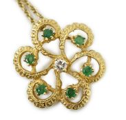 A modern yellow metal, emerald and diamond set stylised flower head pendant, 25mm, on a 375 chain,
