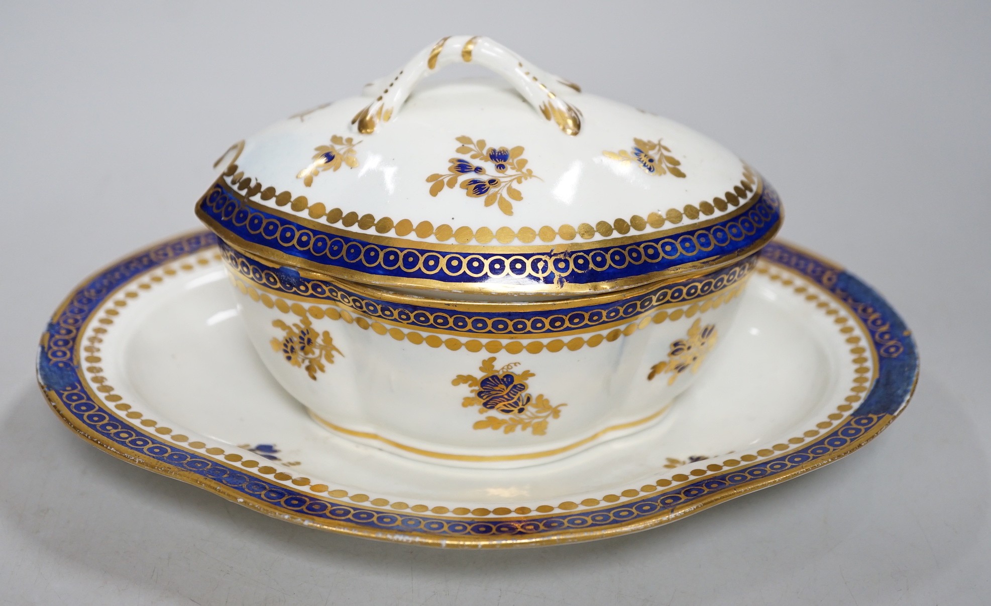 An 18th century Caughley tureen cover and stand with blue and gilt decoration, stand mis-fired to