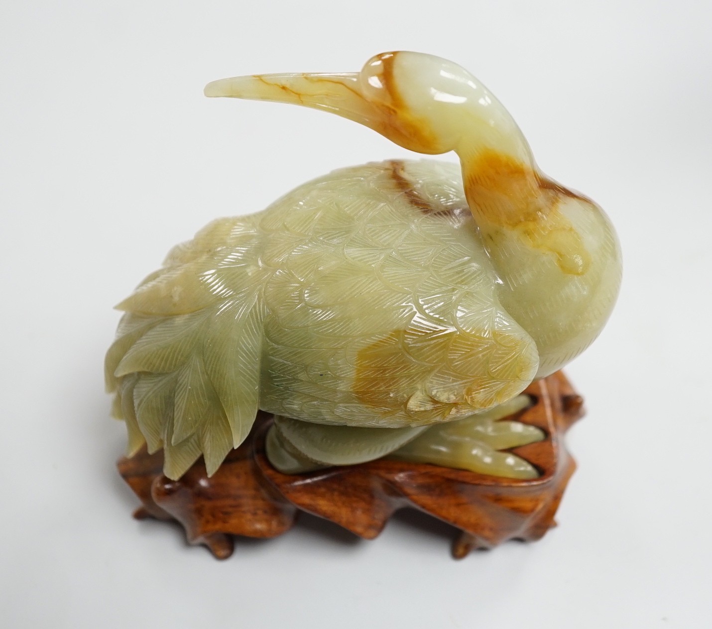 A Chinese green and russet jade figure of a crane, 11.5cm long, wood stand Provenance - the former - Image 2 of 2