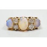 A late Victorian 18ct gold, three stone white opal and four stone diamond set half hoop ring, size