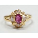 A modern 18ct gold, single stone ruby and trapeze and round cut diamond cluster set dress ring, size