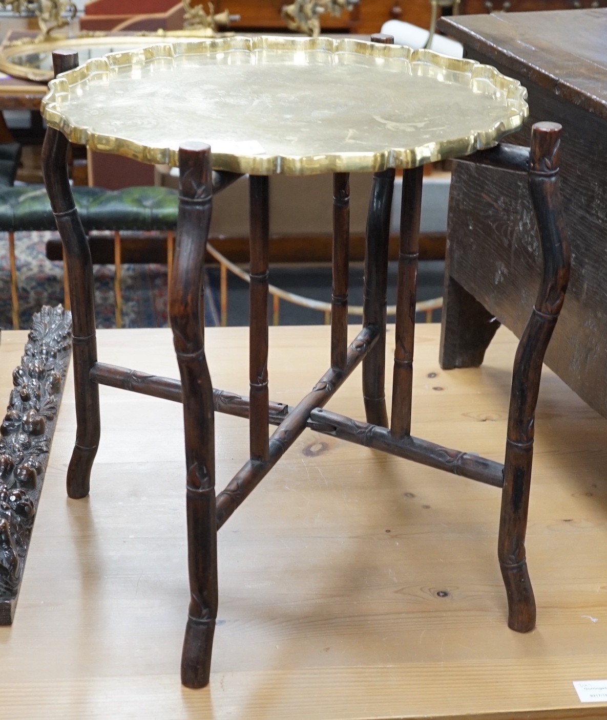 A Chinese brass tray topped hongmu folding occasional table, diameter 56cm *Please note the sale
