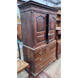 A George III oak press cupboard with two panelled doors over five drawers, width 111cm, depth