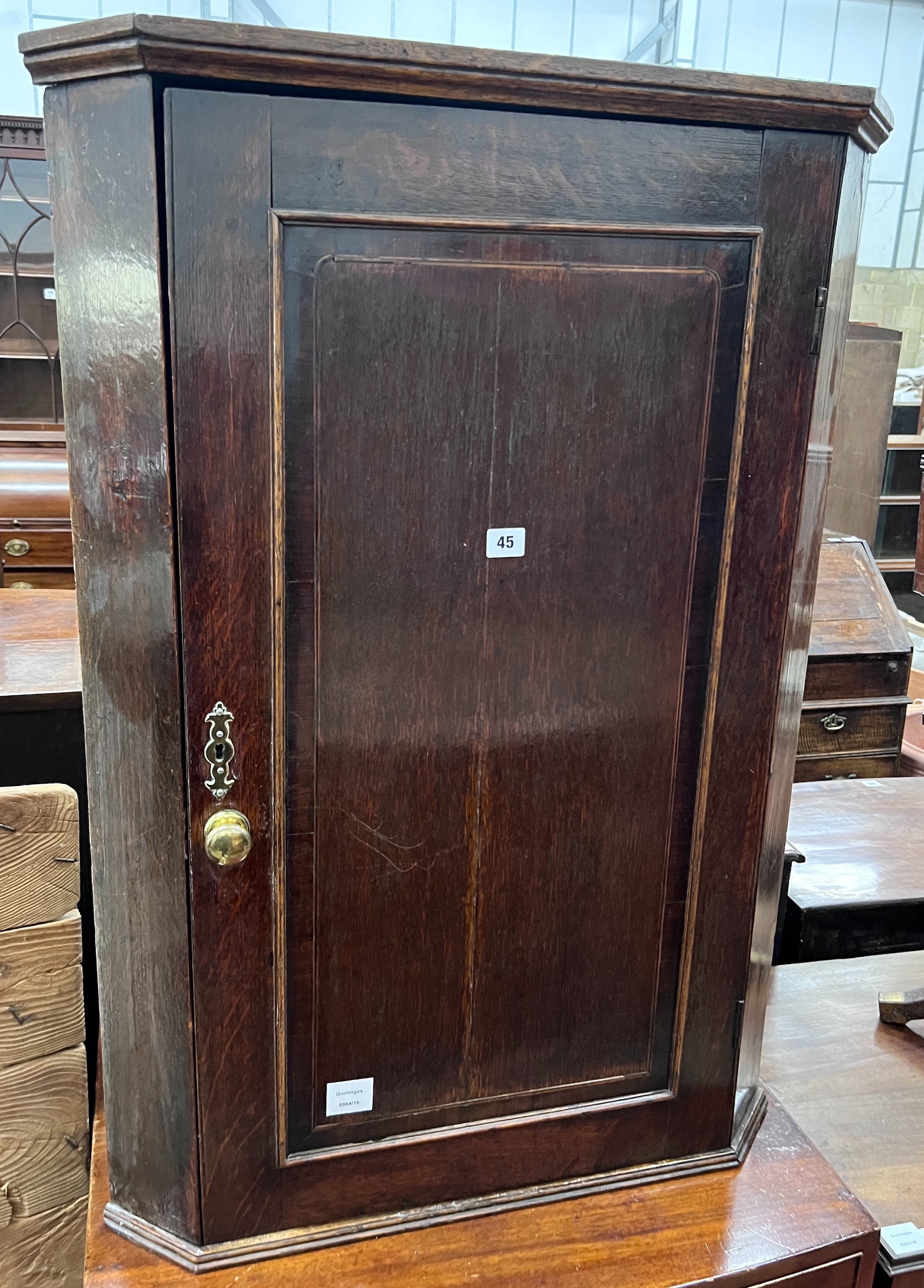 A George III oak hanging corner cupboard, width 69cm, depth 40cm, height 97cm *Please note the