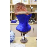An early 20th century 'Prima Donna' red velvet corset mannequin on turned stand with a
