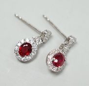 A modern pair of 750 white metal, ruby and diamond cluster set drop earrings, 13mm, gross weight 2.3