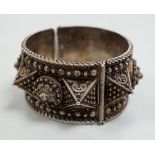 A Middle Eastern white metal hinged bangle.