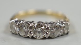 A gold and graduated five stone diamond set half hoop ring, size G/H, gross weight 2.7 grams.