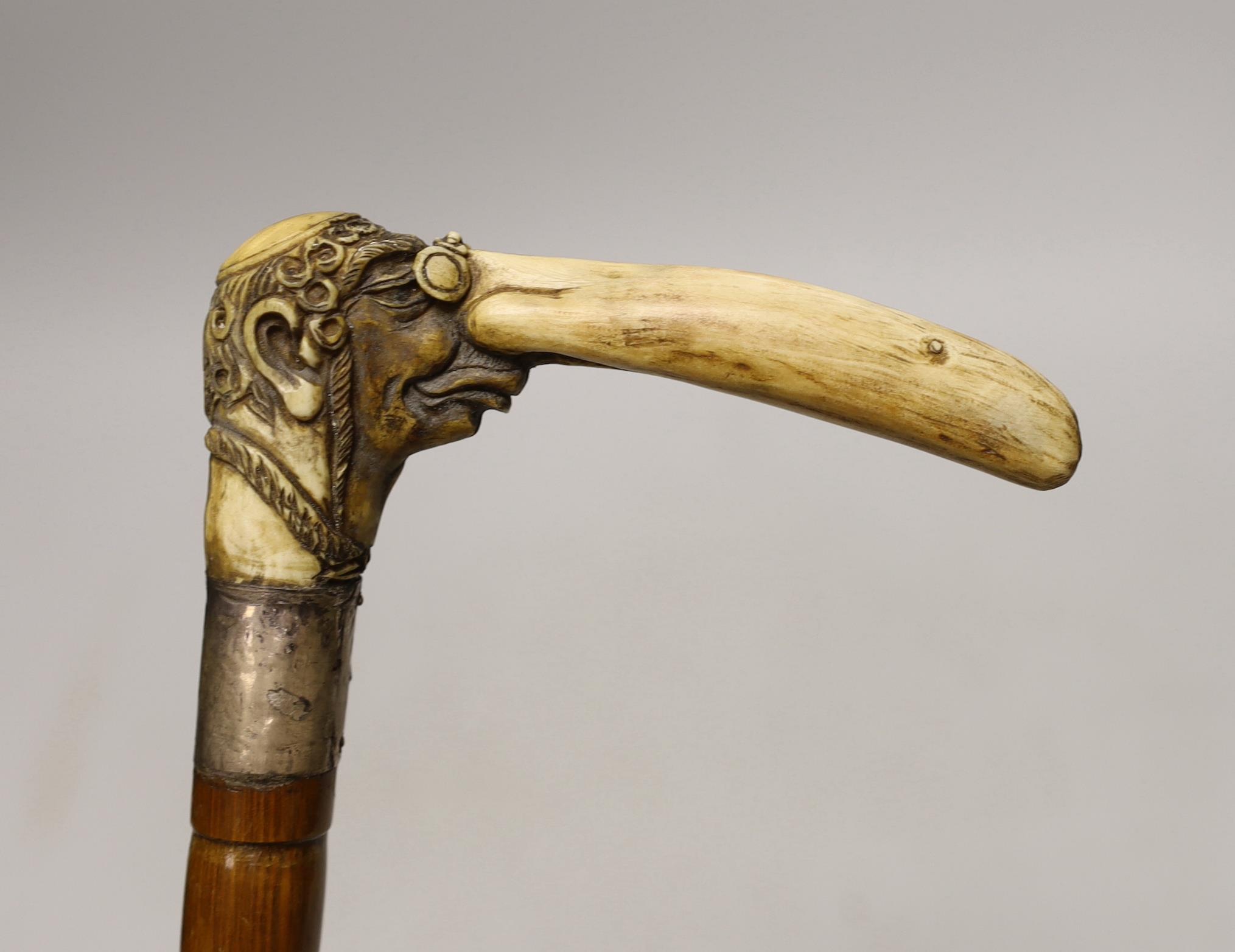 A stag horn handled walking stick with Jewish caricature, 81cm