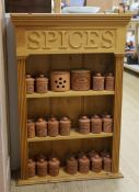 A pine kitchen spice rack with Henry Watson Pottery ‘Original Suffolk Canister’ set