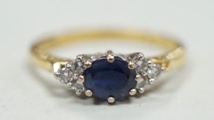 A modern 18ct gold, single stone sapphire and six stone diamond chip set ring, size O/P, gross