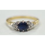 A modern 18ct gold, single stone sapphire and six stone diamond chip set ring, size O/P, gross