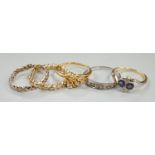 Three assorted white or yellow metal and gem set rings, including sapphire and diamond four stone