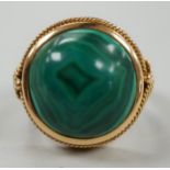 A yellow metal and cabochon malachite set dress ring, size F/G, gross weight 10 grams.