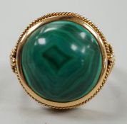 A yellow metal and cabochon malachite set dress ring, size F/G, gross weight 10 grams.