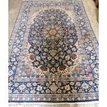 An Iranian silk blue ground carpet with central foliate motifs, 240 x 151cm