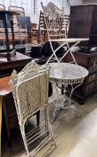 A white painted wrought iron garden table and four folding chairs