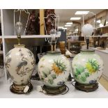 A pair of floral reverse decorated glass decorative table lamps and a similar crackle ware table