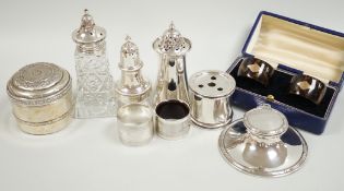 A group of mixed silver including three sugar casters, two inkwells, two pairs of napkin rings (