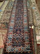 A Persian blue ground runner with field of stylised floral motifs, 428 x 83cm