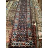 A Persian blue ground runner with field of stylised floral motifs, 428 x 83cm