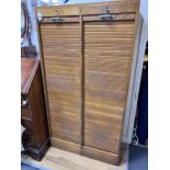 An early 20th century golden oak double tambour front office cabinet, width 82cm, height 150cm