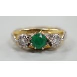 A modern yellow metal, emerald and diamond set three stone ring, size G, gross weight 3.8 grams.