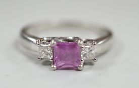 A modern platinum, single stone square cut pink sapphire and two stone diamond set ring, size N/O,