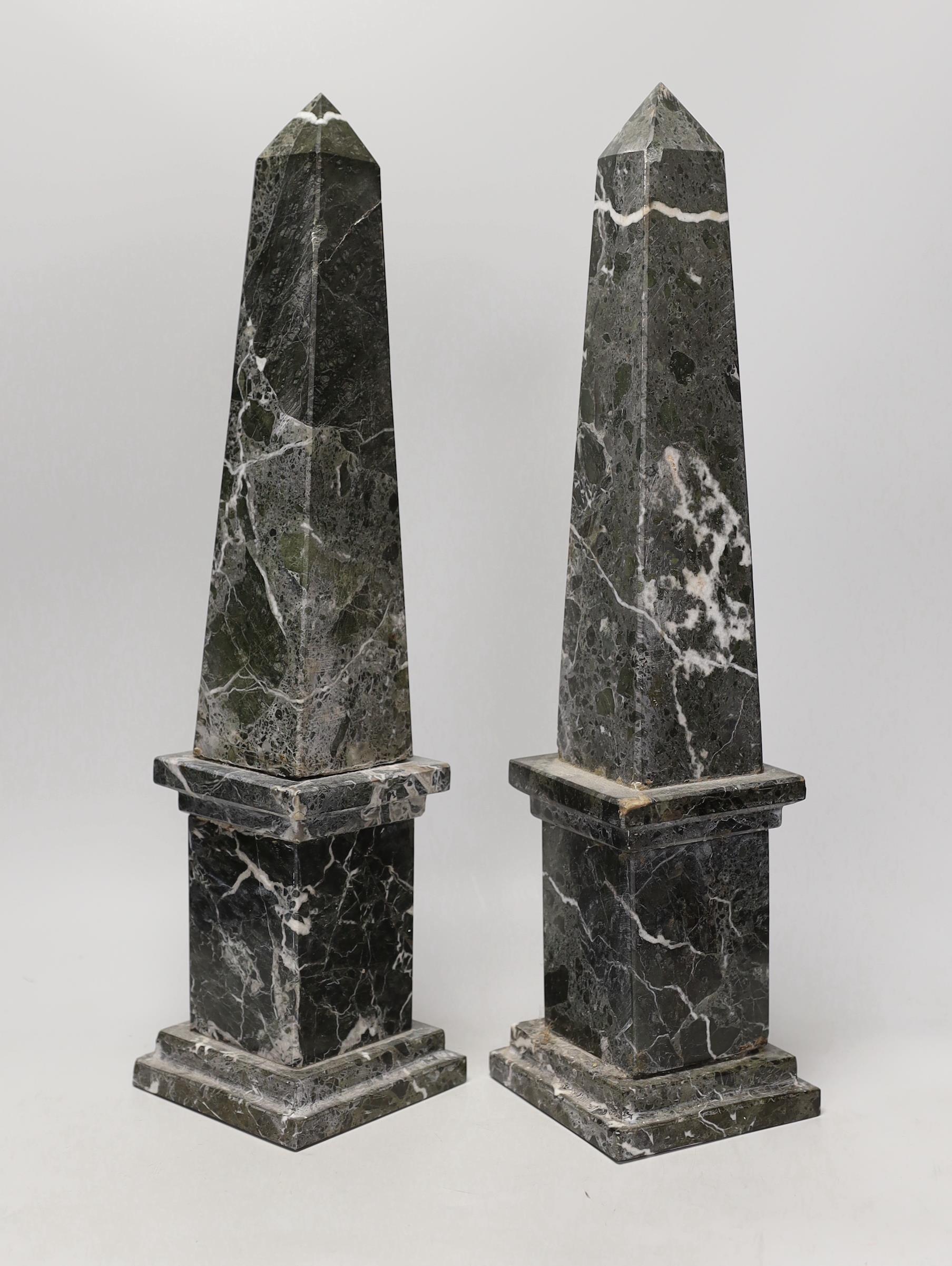 A pair of black and white variegated marble obelisks, 48cm