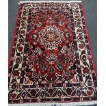 A Persian red ground rug, 204 x 151cm