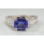 A modern 18ct gold and single stone emerald cut tanzanite set dress ring, with graduated baguette