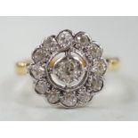 An 18ct and illusion set diamond circular cluster ring, size N, gross weight 5.1 grams.
