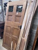 A panelled oak door with inset stained glass panels, width 78cm, height 194cm, another panelled