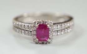 A modern 18ct white gold, single stone emerald cut ruby and diamond chip set cluster ring, with