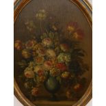 English School c.1920, oil on panel, Still life of flowers in a vase on a ledge, oval, 66 x 47cm