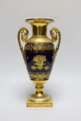 A fine Paris porcelain vase with two handles, highly gilded, the blue ground with a basket of