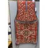 An early 20th century Turkish red wool ground saddlebag, embroidered with multicoloured wools and