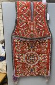 An early 20th century Turkish red wool ground saddlebag, embroidered with multicoloured wools and