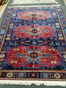 A Caucasian blue ground rug with geometric medallion design, 230 x 182cm