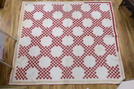 A 19th century Irish chain quilt with red and beige fabric on cream background American