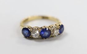 An 18ct gold, three stone blue paste and two stone diamond set half hoop ring, size O, gross