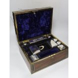 A George IV brass mounted rosewood travelling toilet box, with eleven silver mounted glass toilet