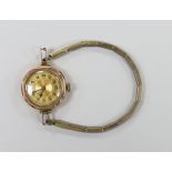 An early 20th century 9ct gold manual wind wrist watch, on a gilt metal flexible strap.